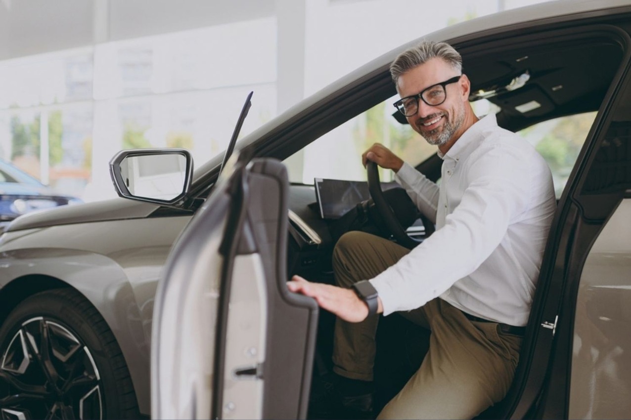 stock photo side view adult cheerful fun man customer male buyer client wear shirt sit in car open door choose 2459261099 (1)